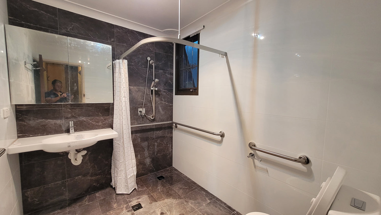 "Bathroom home modification essentials for elderly and accessibility, including a handheld shower, grab rail, bidet, and Quoss mixer for safety and convenience."
